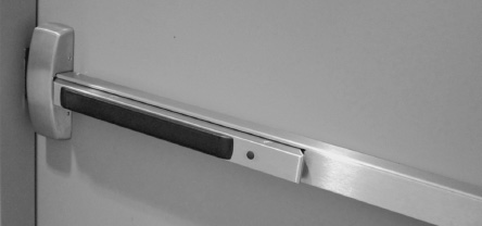 FIGURE 2.5. Panic Bars on Doors. People fleeing a fire would die if they encountered exit doors that opened inward, because they would keep trying to push them outward, and when that failed, they would push harder. The proper design, now required by law in many places, is to change the design of doors so that they open when pushed. Here is one example: an excellent design strategy for dealing with real behavior by the use of the proper affordances coupled with a graceful signifier, the black bar, which indicates where to push. (Photograph by author at the Ford Design Center, Northwestern University.)